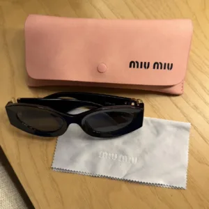 Miu Miu Women's Black and Gold Sunglasses